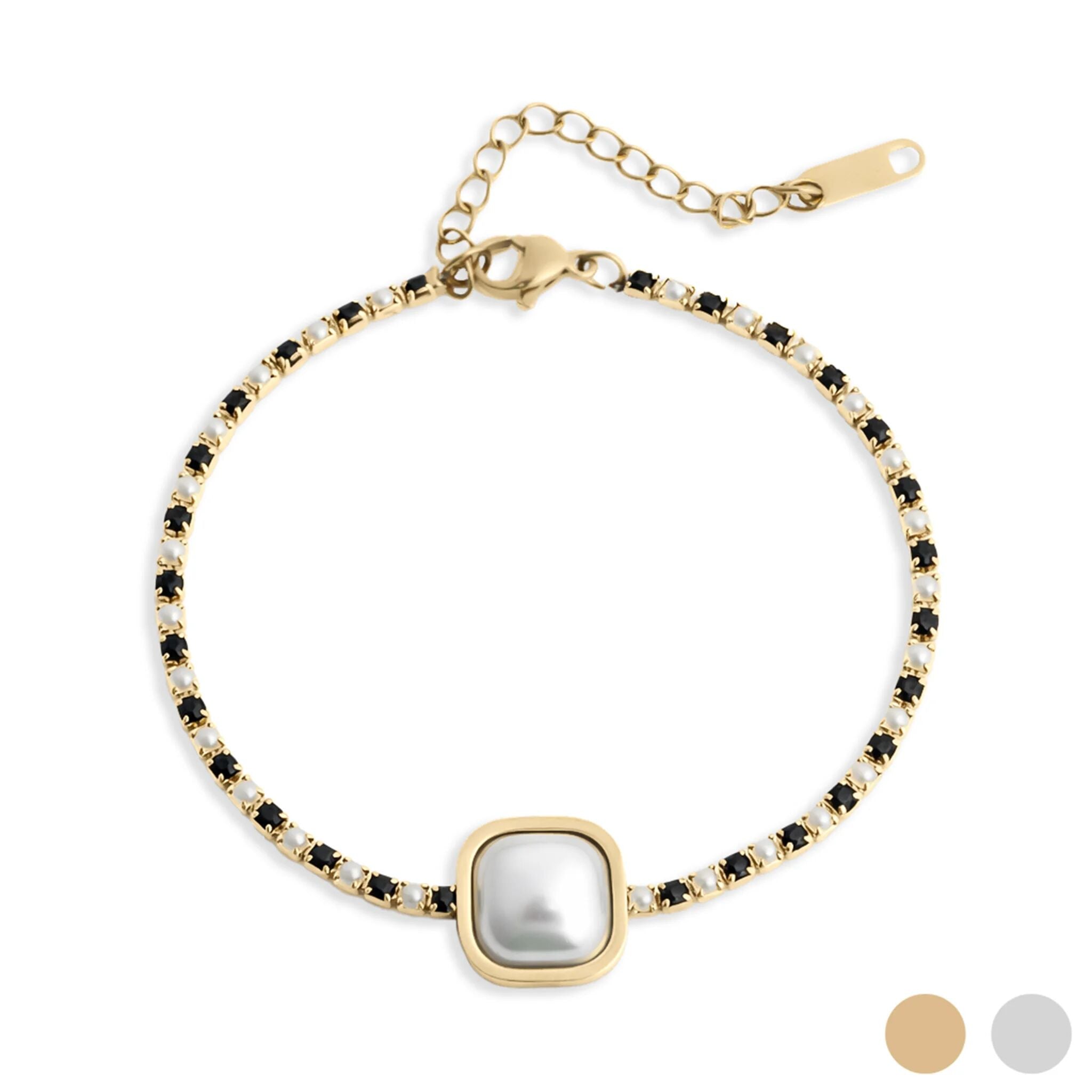 Gold bracelet with a central pearl and black stones on a white background