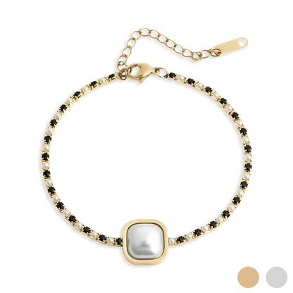 Gold bracelet with a central pearl and black stones on a white background