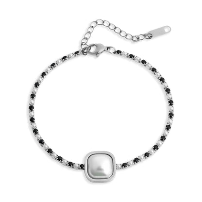 Silver bracelet with a central pearl-like bead on a white background